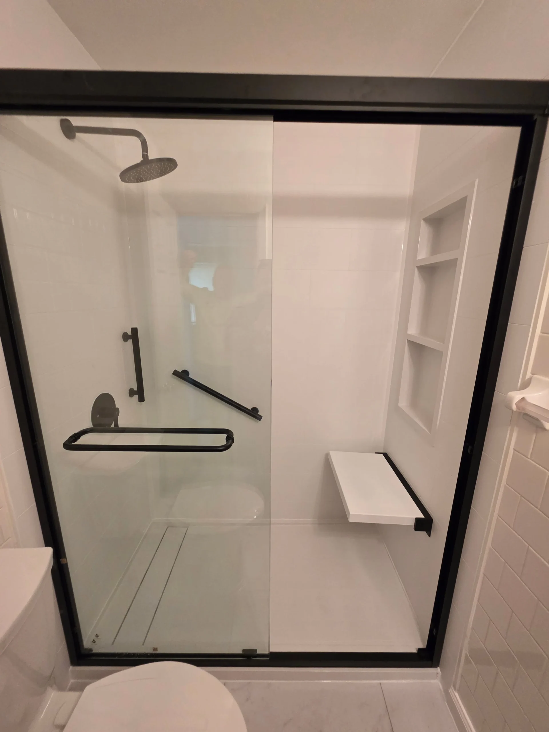 Walk-in shower installation in Chesapeake Beach MD featuring white wall panels and accessibility upgrades